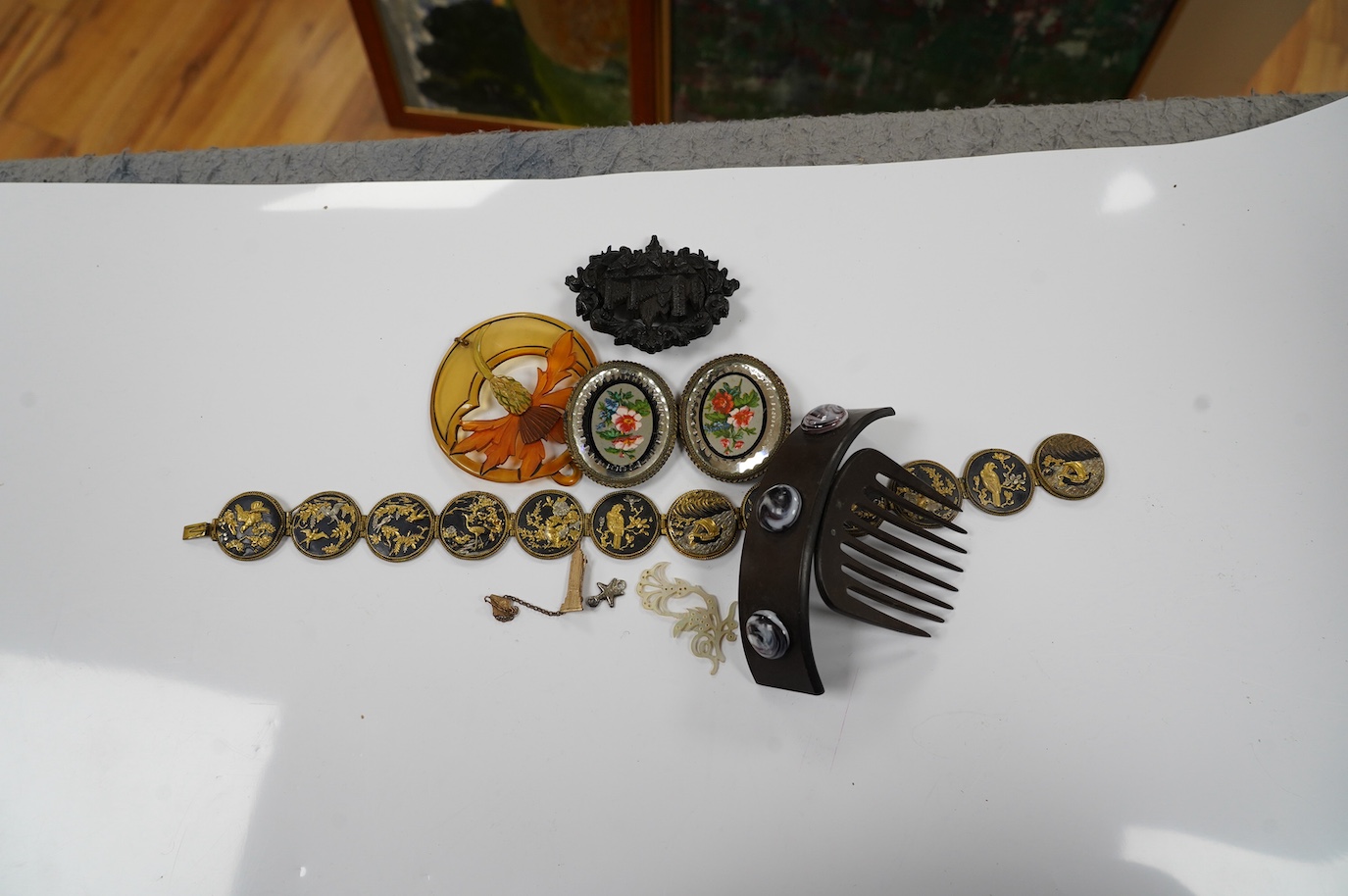 A French Bois Durci brooch, a French carved and stained horn pendant, a hair comb, ornate glass belt buckle and Japanese mixed metal choker necklace 36cm long. Condition - good